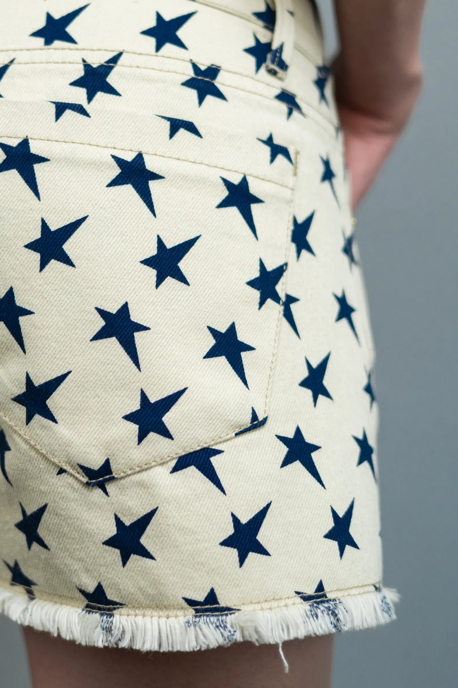 Star Denim Shorts — Off-White w/ Blue Stars — back pocket angle — Andrew Charles SS26